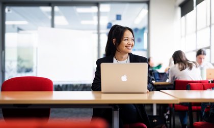 Woman using laptop on campus.