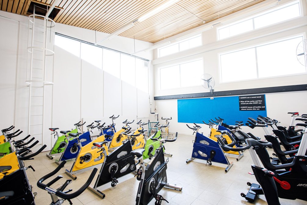 Dedicated spin class room containing 24 bikes, arranged facing one bike for the spin-class instructor