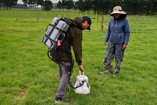 two people standing in a field using portable trace gas analysers