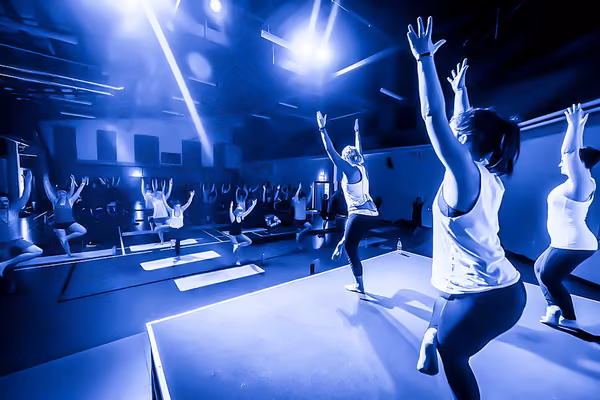 Students being led by fitness instructors in an exercise class at Les Mills gym