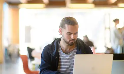 Student on laptop at desk.