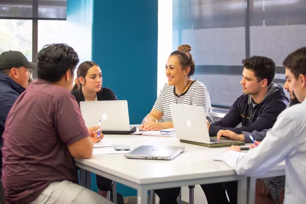 Group of students sitting at a table having a conversation.