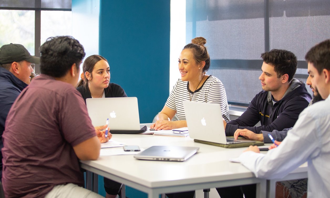 Group of students sitting at a table having a conversation.