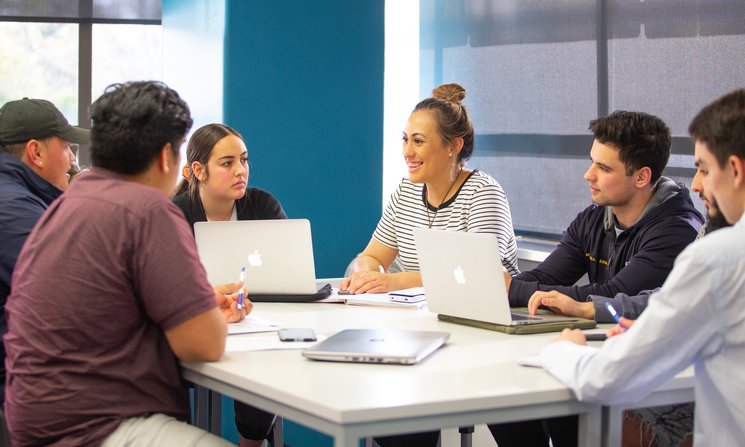 Group of students sitting at a table having a conversation.