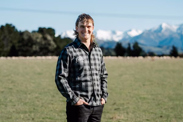 Man in plaid shirt standing out in a field