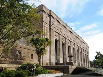 Exterior of the Museum building with wide steps, with a tree in the foreground