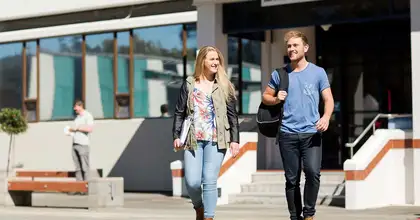 Two students walking outside library