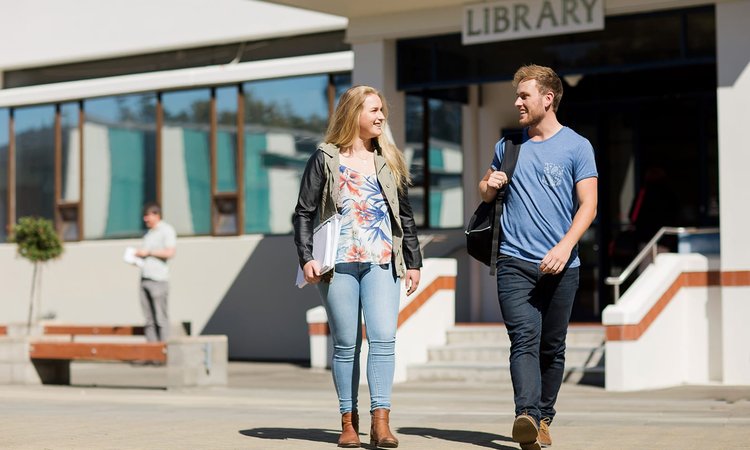 Two students walking away from the campus library