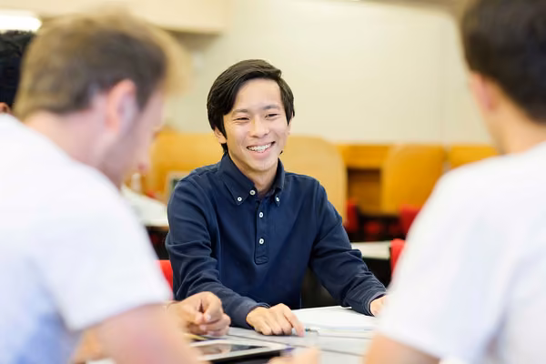 Three students sitting around a table, studying