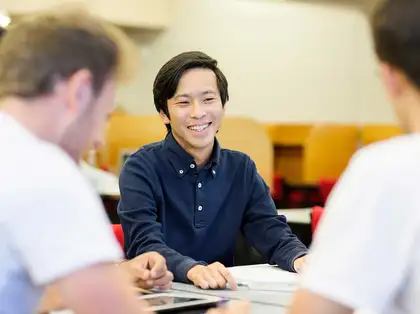 Three students sitting around a table, studying