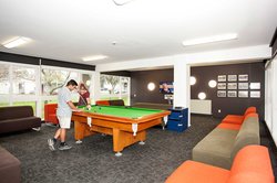 Lounge in Colombo Hall with two students playing a game of pool