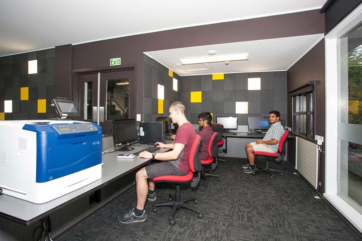 Computer lab in Colombo Hall with several students sitting at desks using desktop computers