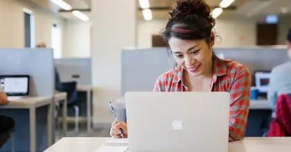 Student using a laptop at a desk in the library