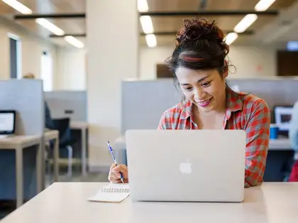 Student using a laptop at a desk in the library