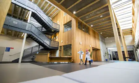 Two people walk through the entrance hall of the Vet Science building, Tāwharau Ora.