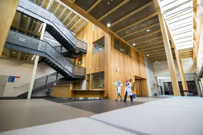 Two people walk through the entrance hall of the Vet Science building, Tāwharau Ora.