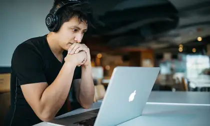 Distance male student studying with laptop.