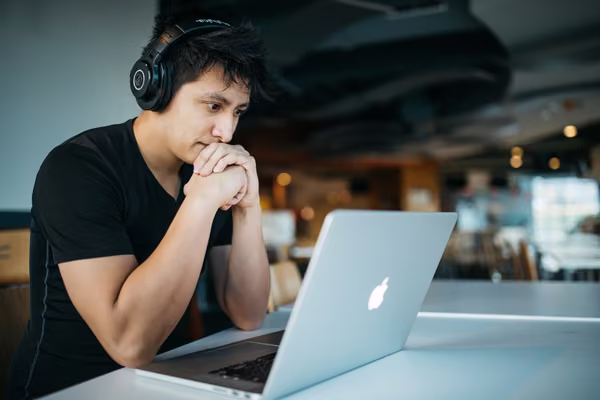 Distance male student studying with laptop.
