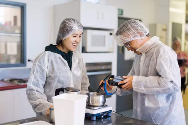 students in hair nets working in industrial kitchen