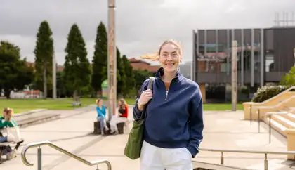 Student standing outside on campus in Auckland.