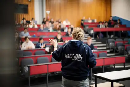 woman speaking to lecture hall full of students