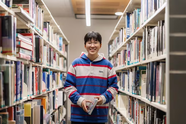 Massey student in library on campus.