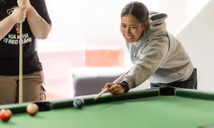 Students play pool in the lounge on Wellington campus