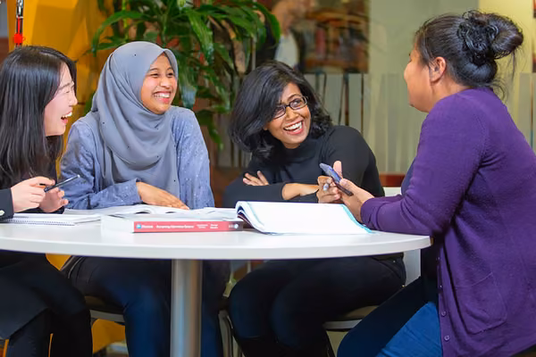 Four smiling people at a table with accounting books