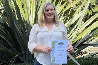 lady smiling holding certificate