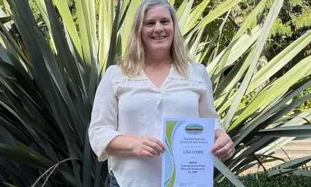 lady smiling holding certificate
