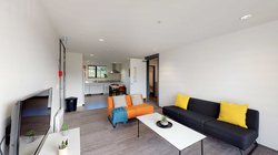 Matipo, Titoki and Tānekaha apartments' lounge area with couches, coffee table and wall mounted TV