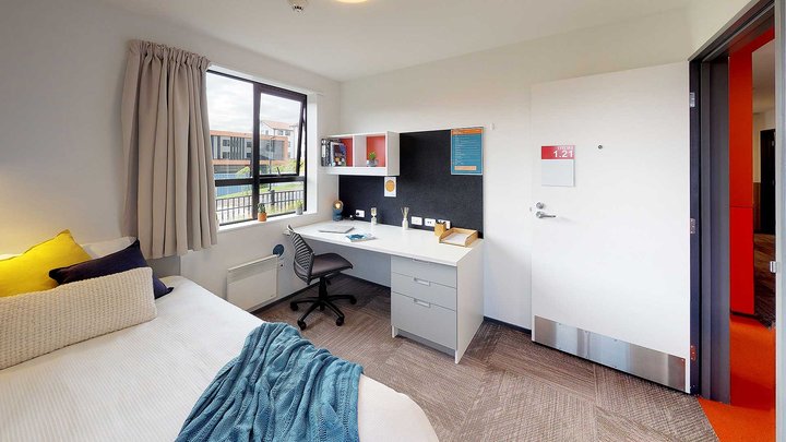 Matipo, Titoki and Tānekaha apartments' bedroom with bed, desk and chair