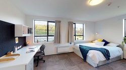 Matipo, Titoki and Tānekaha apartments' double bedroom with bed, desk and chair