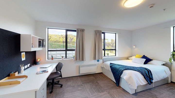 Matipo, Titoki and Tānekaha apartments' double bedroom with bed, desk and chair