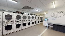 Te Rito laundry with many washing machines and a bench seat