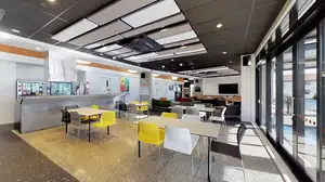 Te Rito's large, airy common area with four dining tables and chairs