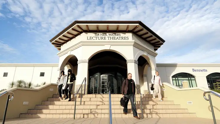 Exterior of Sir Neil Waters building with students exiting down the steps