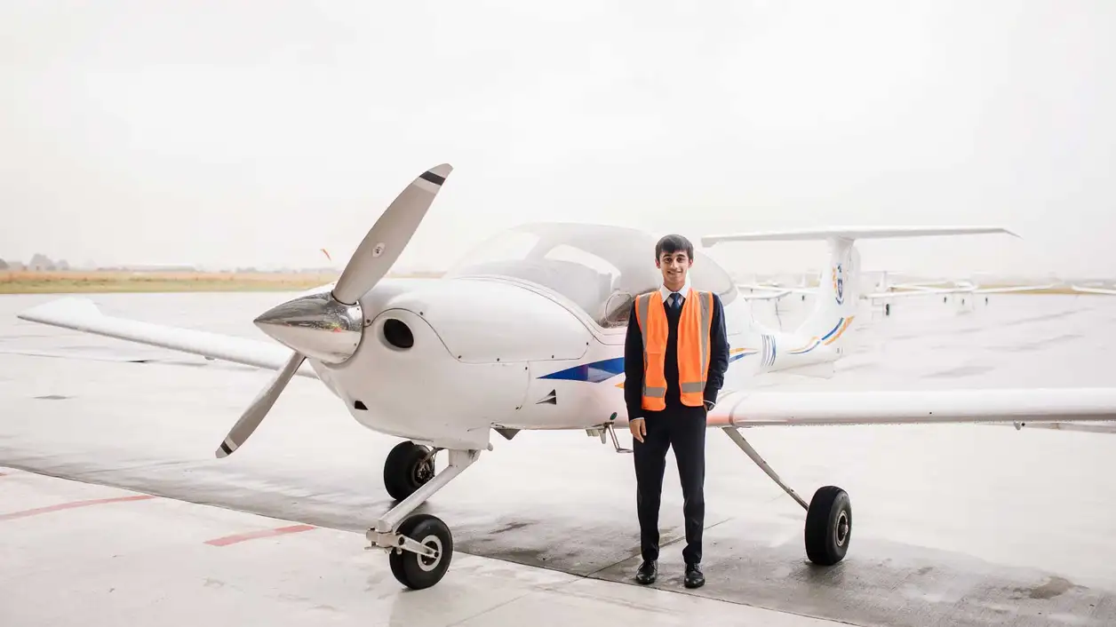 Youthful person standing next to a small plane