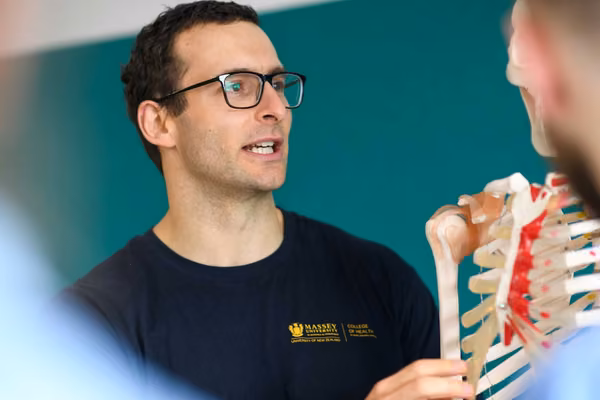 Close up of teacher holding a model skeleton