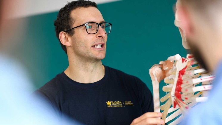 Close up of teacher holding a model skeleton