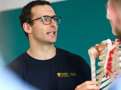 Close up of teacher holding a model skeleton