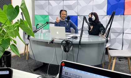 Two people recording a podcast in a media studio