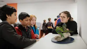 A kaiako and three ākonga look at models of native manu.