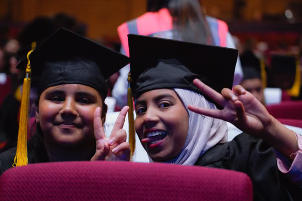 Image of two excited ākonga from Te Kura o Wairau in their graduation robes before their 2024 Whakapōtaetanga Graduation Ceremony.