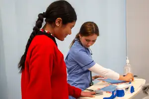 A tamariki and health professional use a finger pulse reader.