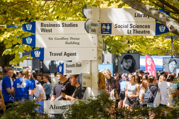 Close-up of signpost and students at Orientation