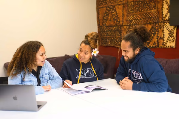 Three young people talking around a table