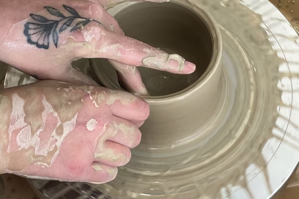Fine arts at Massey - Student using pottery wheel to make a bowl.