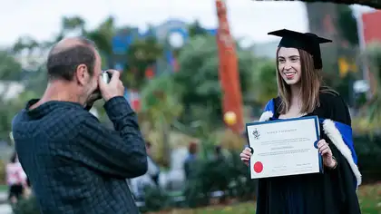 Person taking photo of happy graduate