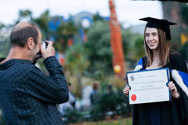 Person taking photo of happy graduate